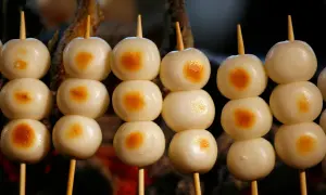Proste japońskie dania: słodkie kluseczki mochi na patyczkach, lekko przypieczone.