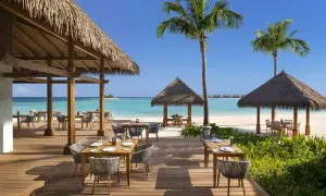 Idealna pogoda na Malediwach w styczniu: słoneczny dzień, turkusowa woda i restauracja na plaży.