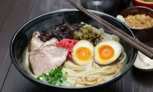 Parujący ramen z grubym makaronem, plastrami wieprzowiny, jajkiem na pół i szczypiorkiem. Idealny wybór, jaki makaron do ramen!