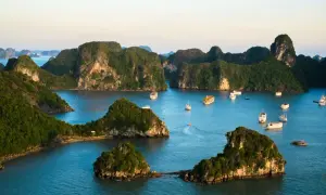 Piękna ha long pogoda. Wiele statków pływa między zielonymi, skalistymi wyspami w zatoce.
