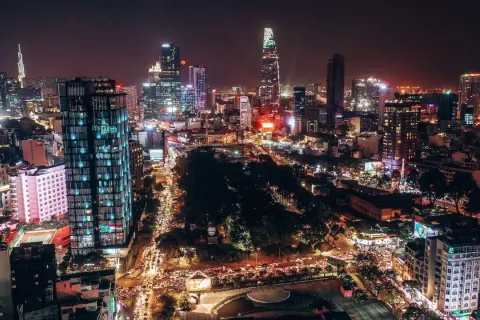 Nocna panorama tętniącego życiem miasta, dawna nazwa miasta Ho Chi Minh, z oświetlonymi drapaczami chmur i ulicami pełnymi ruchu.
